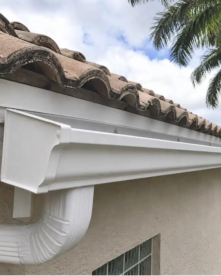 The same gutter and downspout after cleaning, bright white and clear.