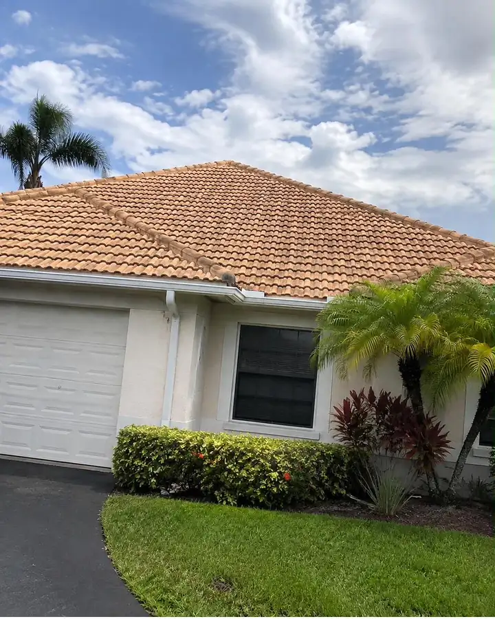 The same barrel tile roof after soft washing, back to a bright salmon terracotta.