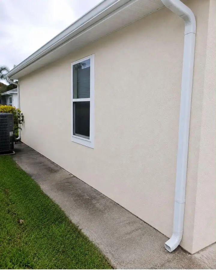 The same stucco wall after a house wash, clean and evenly beige.